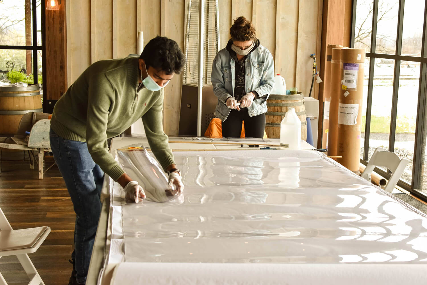 Volunteers assembling face shields from raw materials such as rolls of PET sheeting